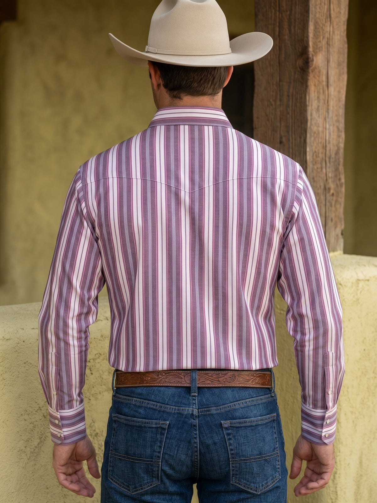 Front view of cowboy wearing Pecos Western burgundy and pink striped pearl snap shirt showing chevron front yokes and flap pockets