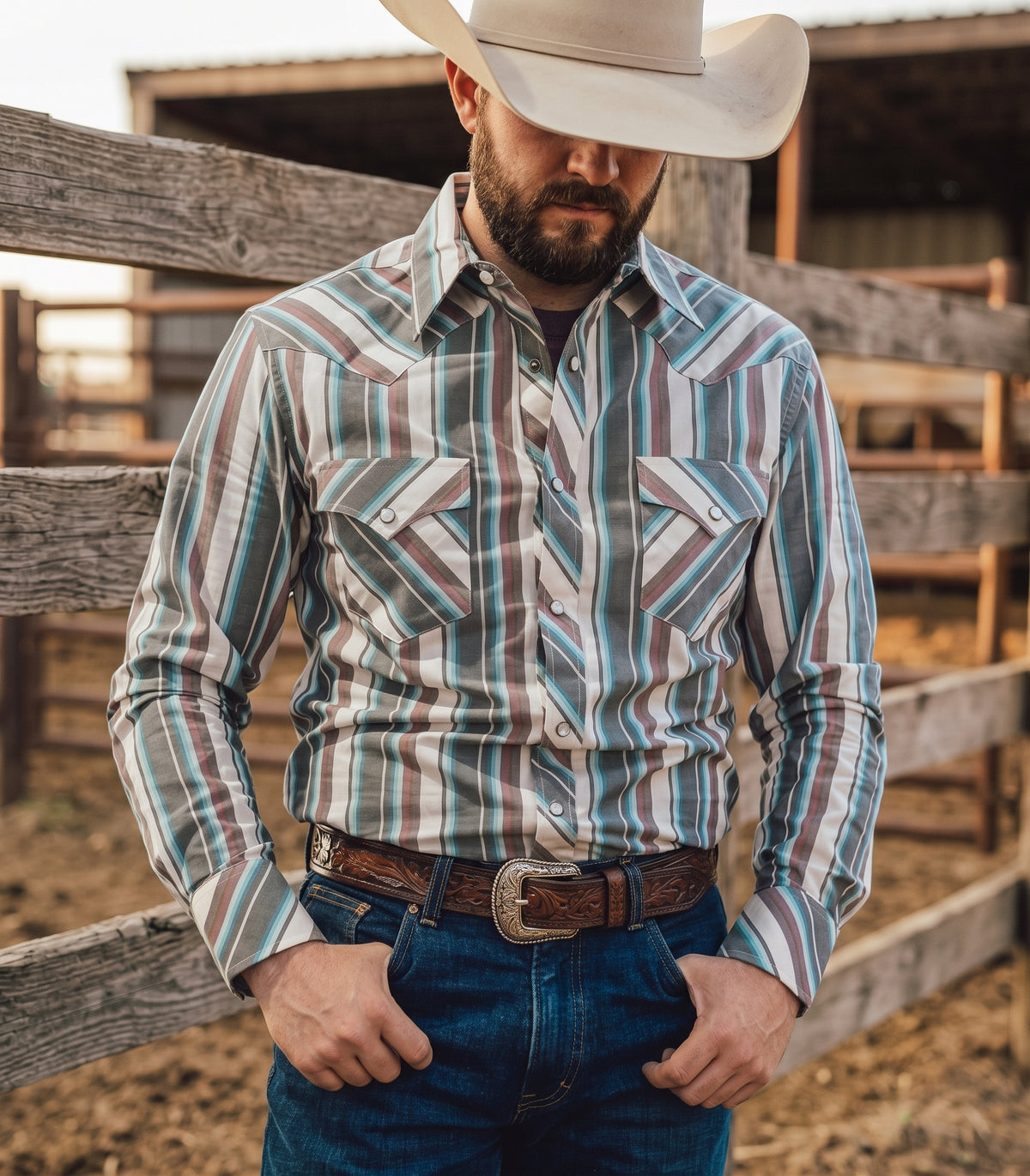 Front view of cowboy wearing Pecos Western grey and turquoise striped pearl snap shirt showing chevron front yokes and pockets