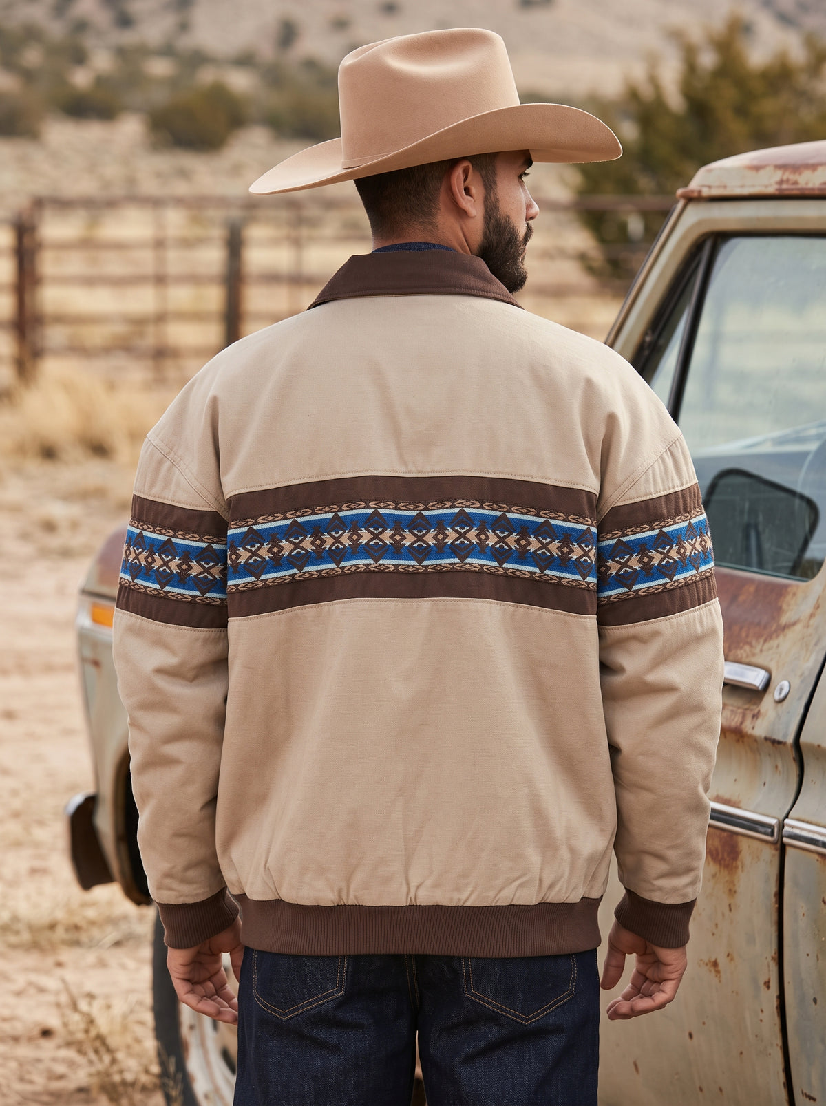 Back view of men's tan Western jacket showing continuous horizontal Aztec geometric pattern and brown collar
